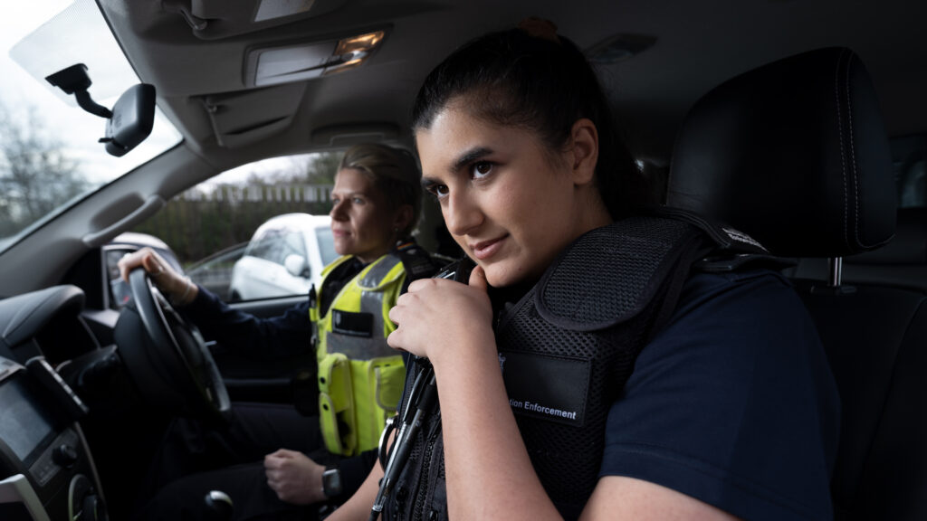Two Immigration Enforcement officers in a vehicle