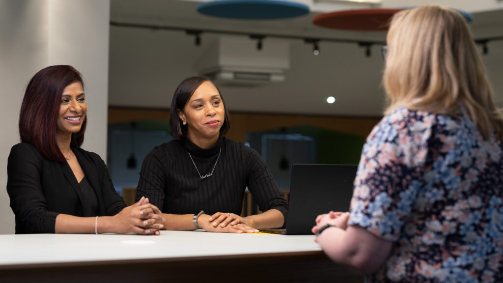 Three members of staff seated around an office table