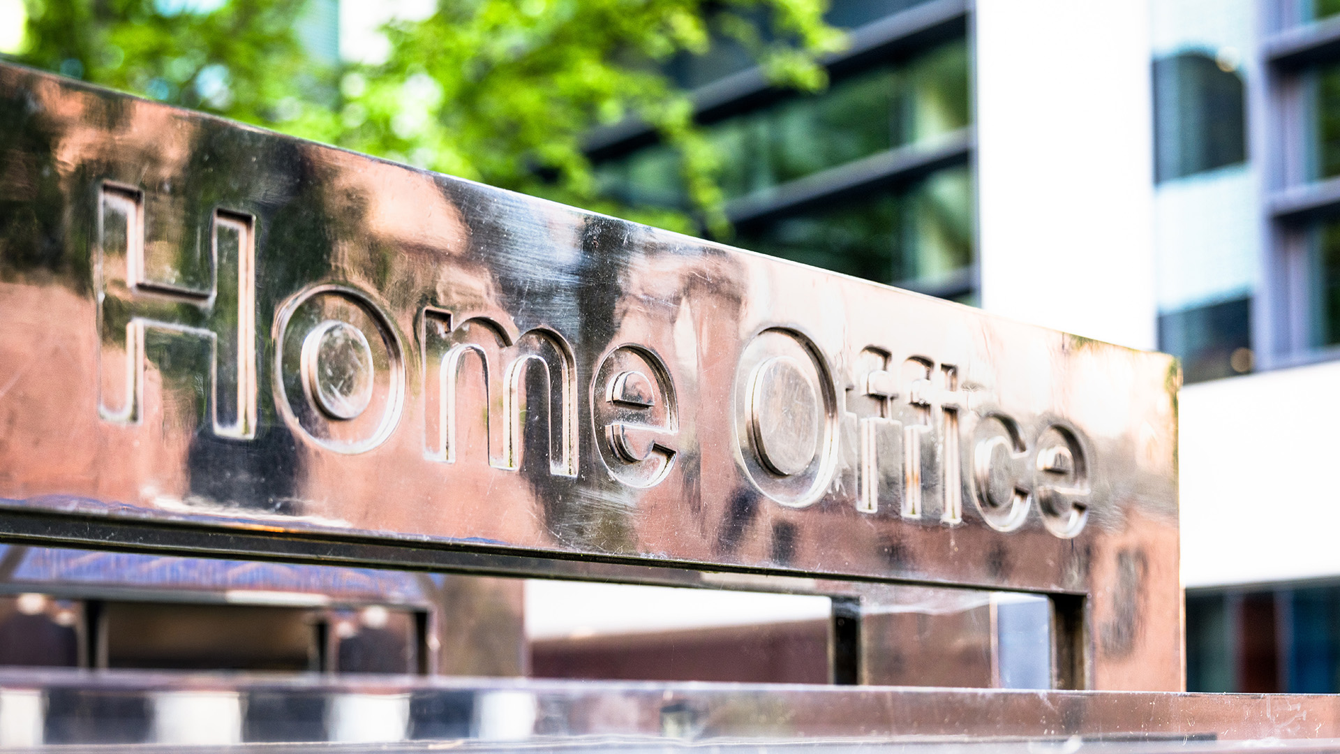 Shiny, silver sign outside an office which reads 'Home Office'